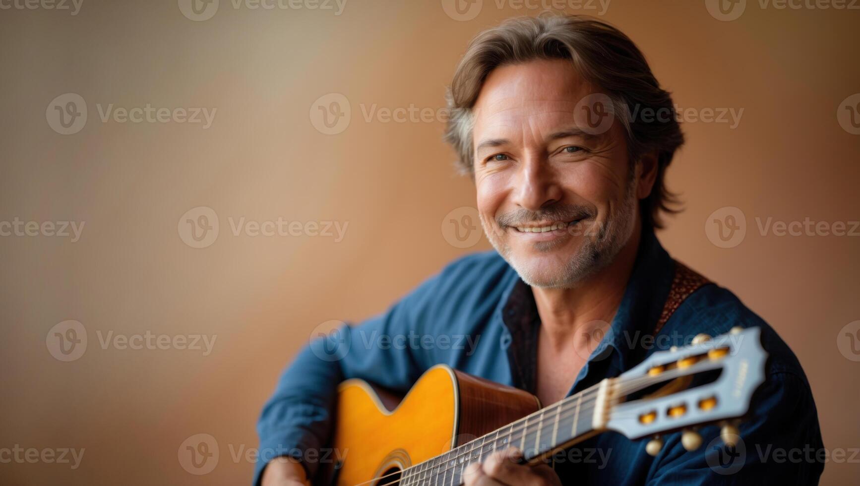 a middle aged man is smiling while holding an acoustic guitar photo