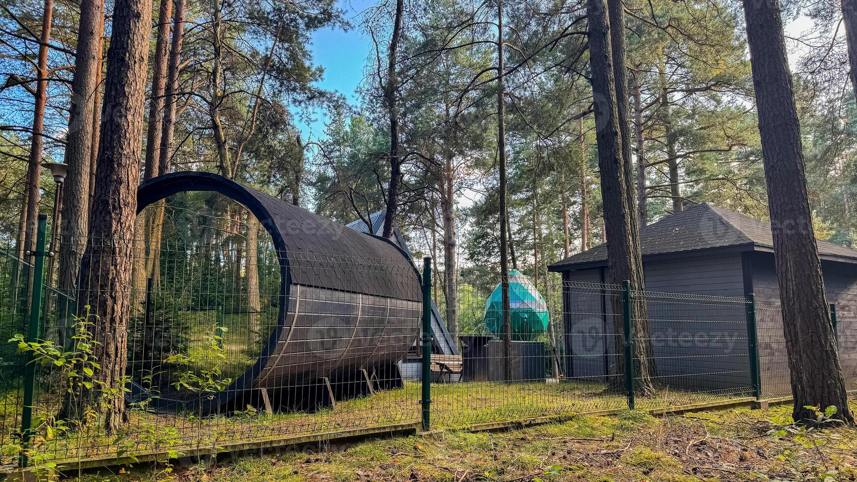 Modern architectural structure nestled in a serene forest with geometric design blending into the natural landscape for a tranquil escape photo