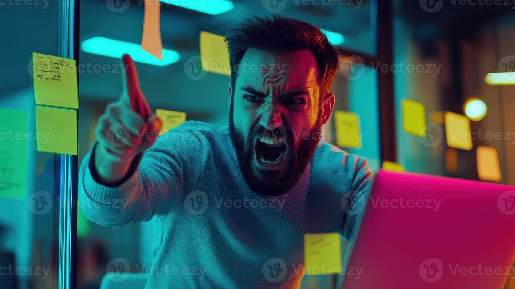 Intense young caucasian male in modern office environment expressing frustration with gestures and expressions among colorful sticky notes. Work environment stressful photo