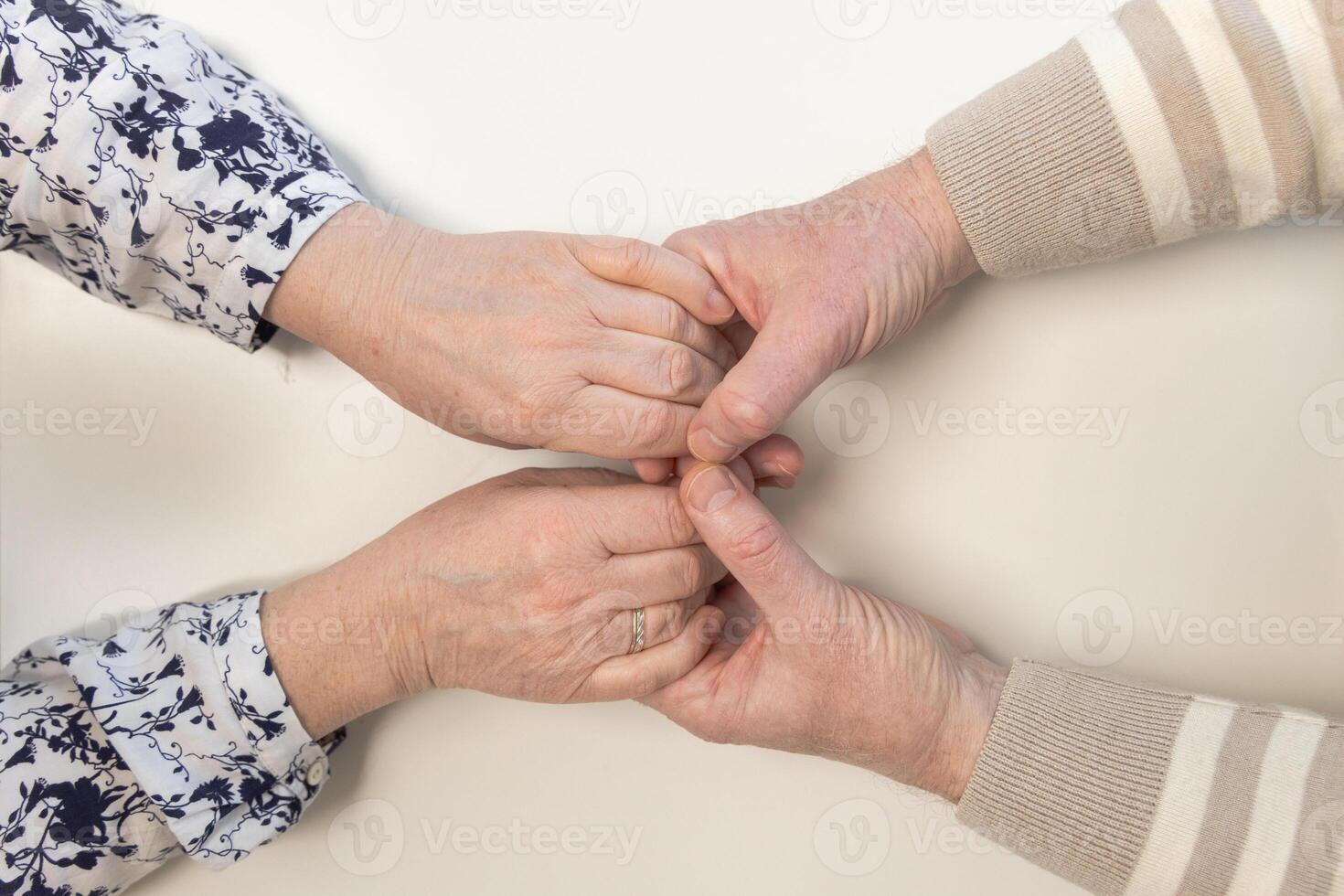 The male female hands, with age-related changes in the skin, symbolize strong bonds, care and support. This shot conveys warmth of family relationships and the trust accumulated over years. photo