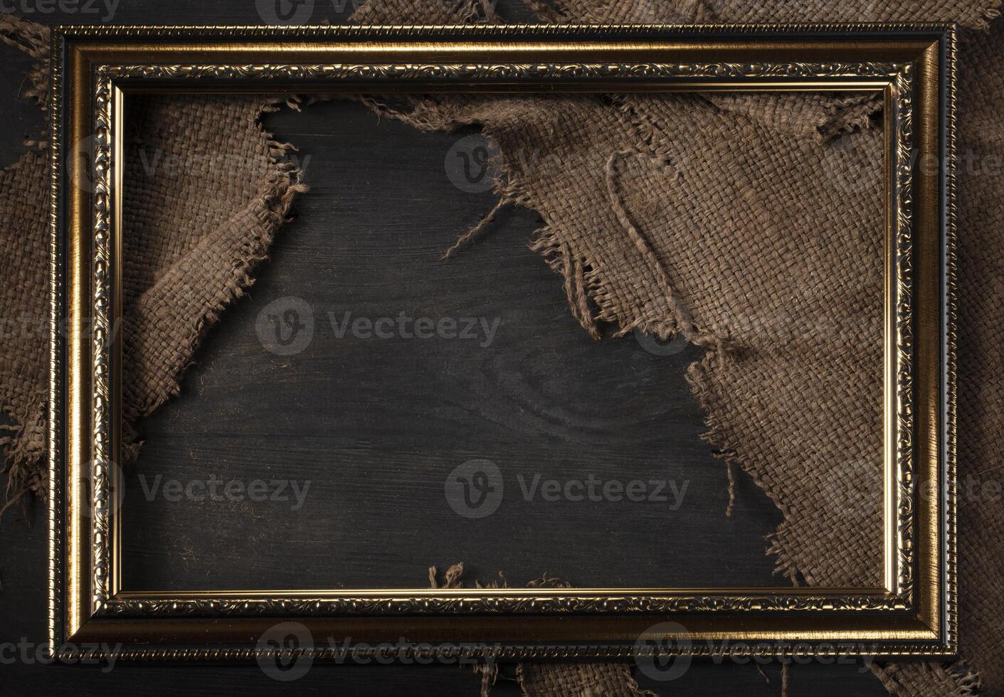 In a beautiful frame, a coarse weave fabric on a wooden background. Background for the inscription. photo