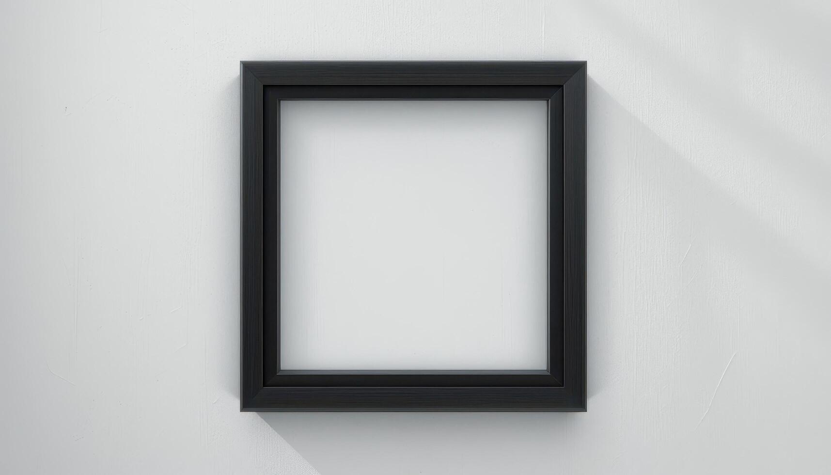 Empty black picture frame against a light background. photo