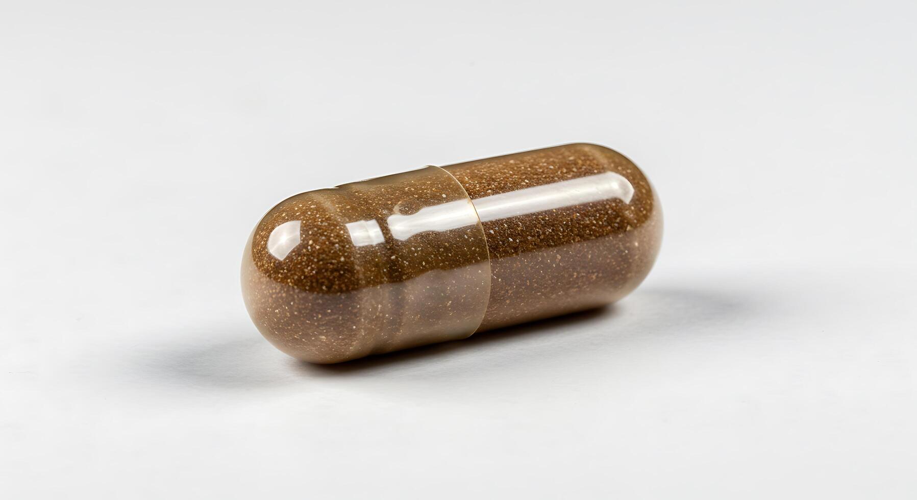 A capsule with brown and white powder inside photo