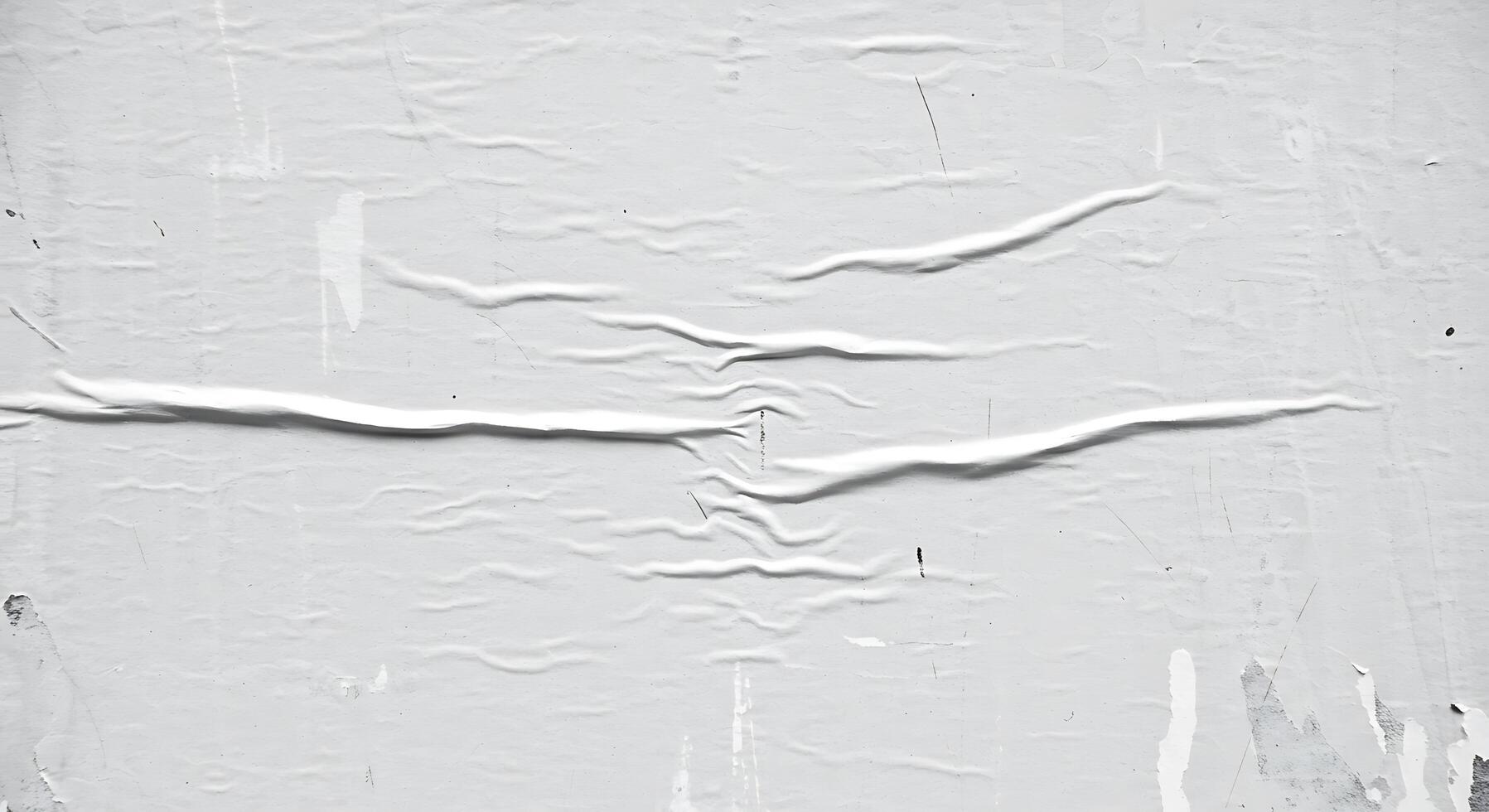 A white wall with peeling paint and a crack photo