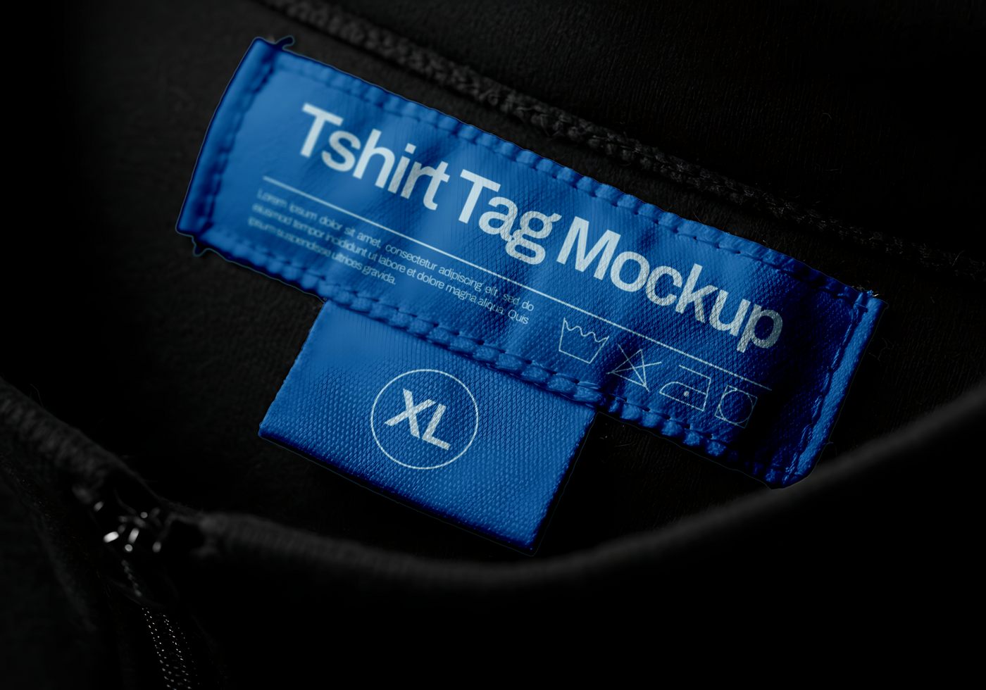 A close up of a blue T shirt tag mockup on a black garment displaying size XL and care instructions psd