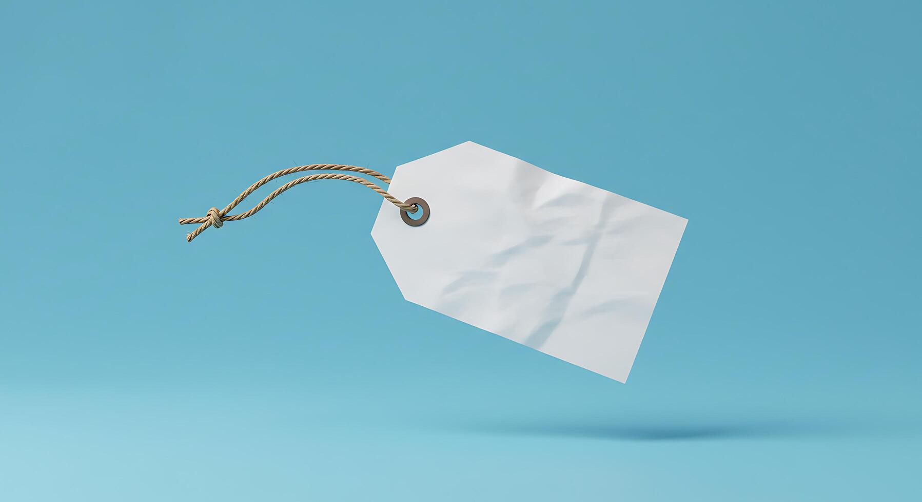 White paper price tag hanging from string on blue background photo