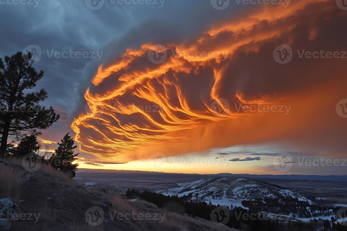 Fiery orange cloudscape illuminating snowy hills and pine trees at sunset photo