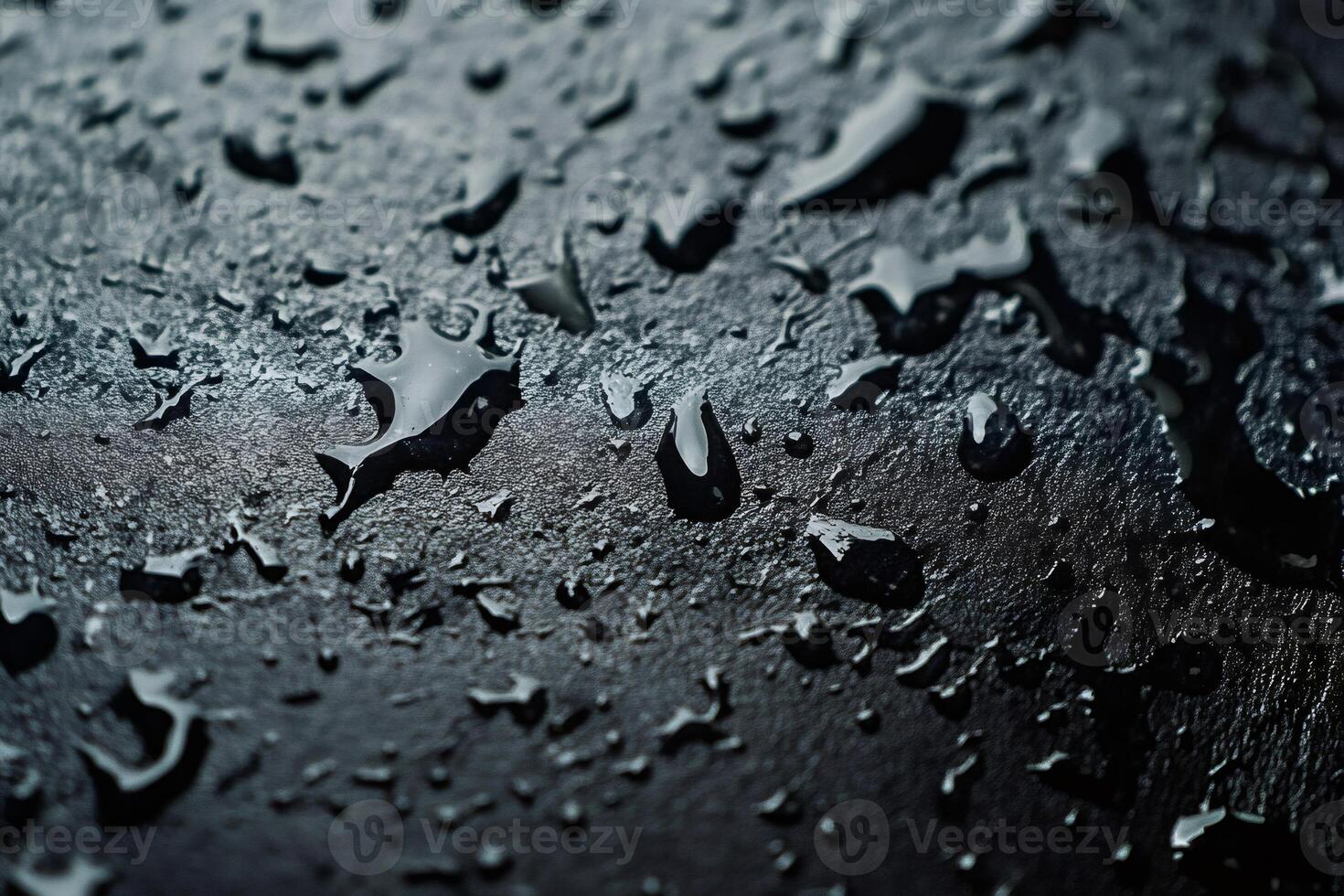 Water droplets creating textured patterns on dark surface photo