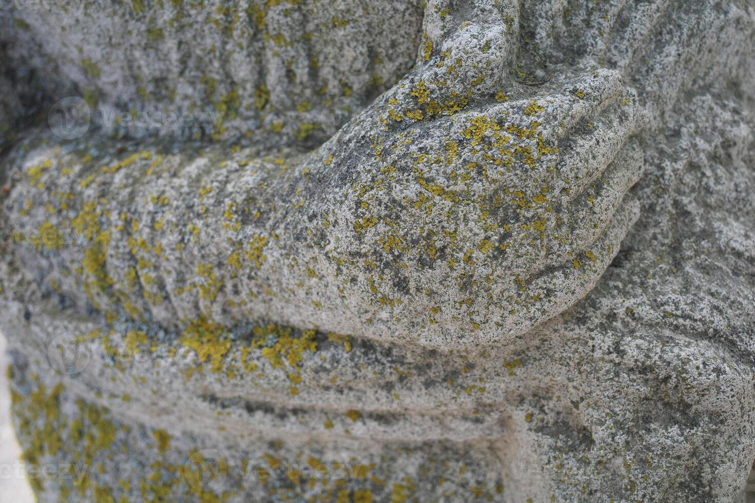 The hands of an ancient statue covered with moss. Hugging and taking care of yourself photo
