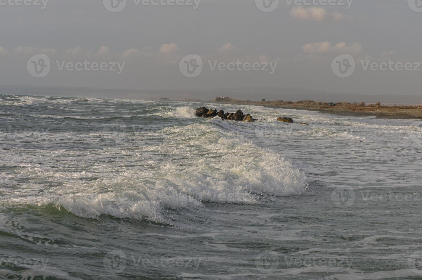 Mediterranean wave crashing on beach rocks in Cyprus photo