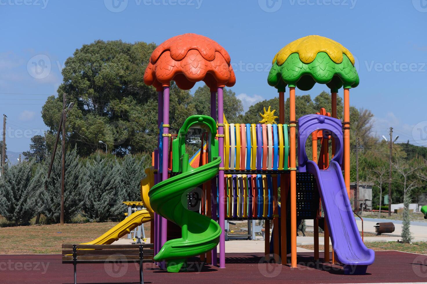 Brightly colored playground structure invites play and imagination in a sunny park setting during the afternoon hours, surrounded by nature's greenery photo