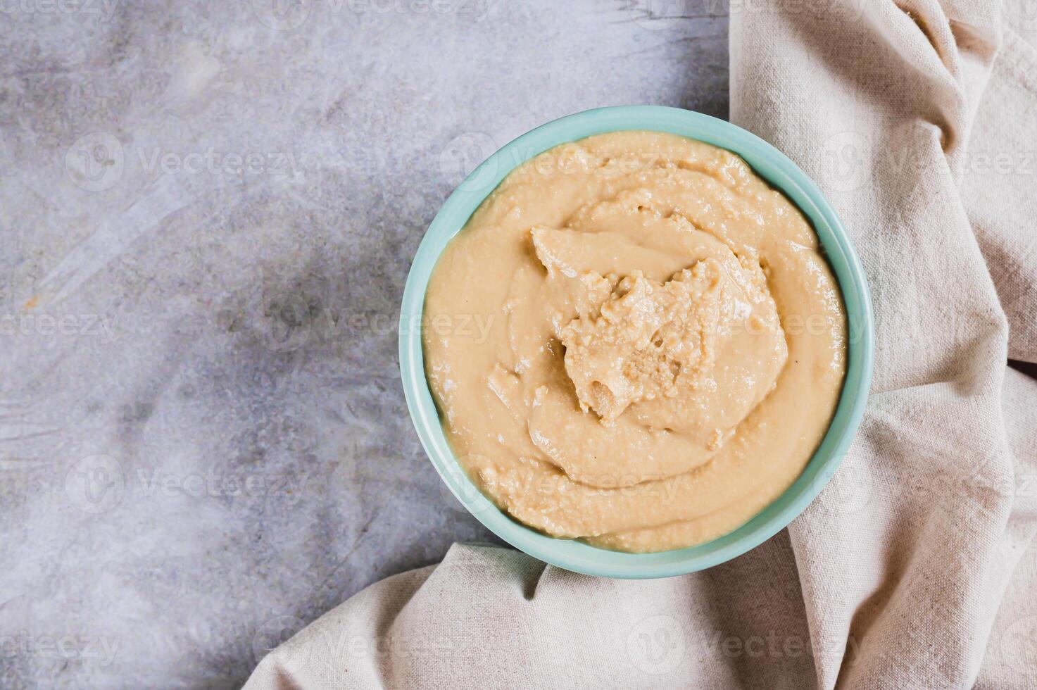 Close up of sesame tahini in a bowl on the table top view photo