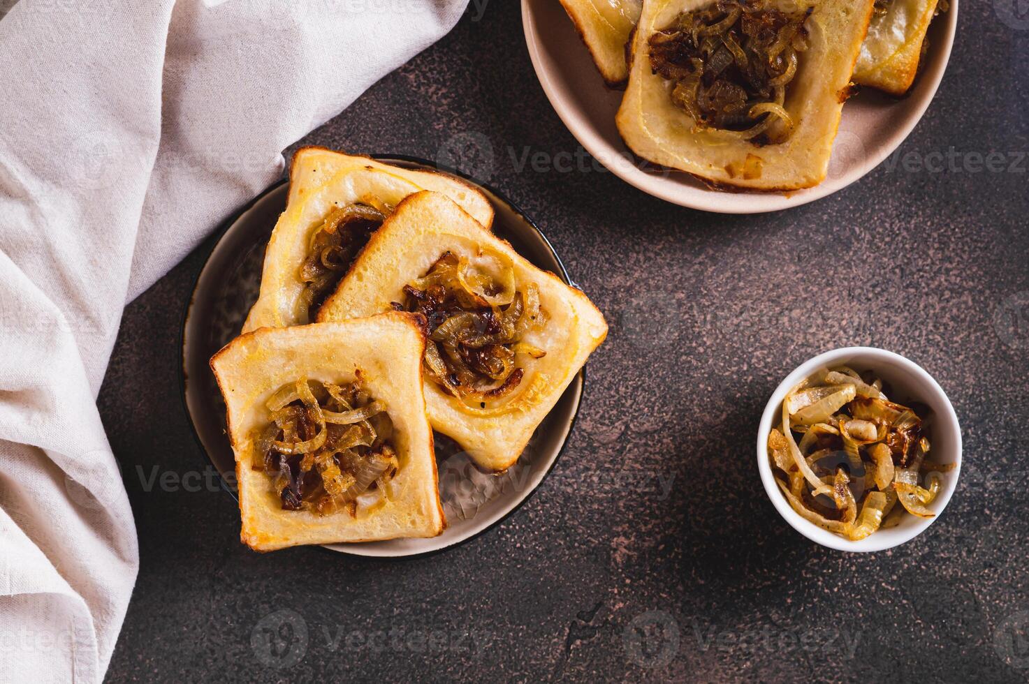 Upside down tarts with caramelized onions on a plate on a table top view photo