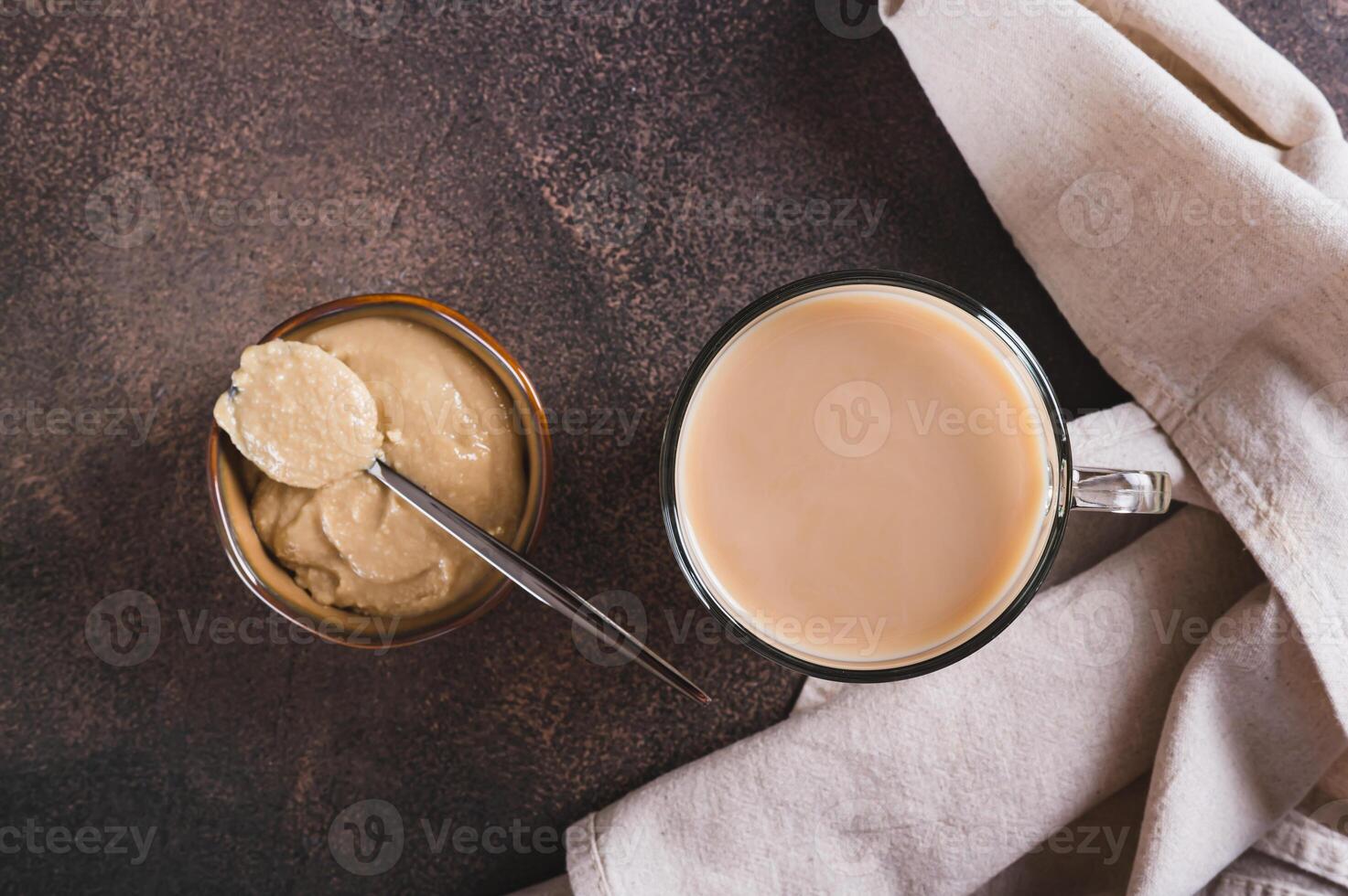 Close up of tahini latte with sesame spread in a cup on the table top view photo