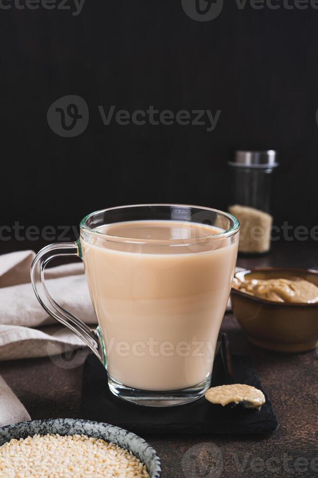 Tahini latte with sesame spread in a cup on the table vertical view photo