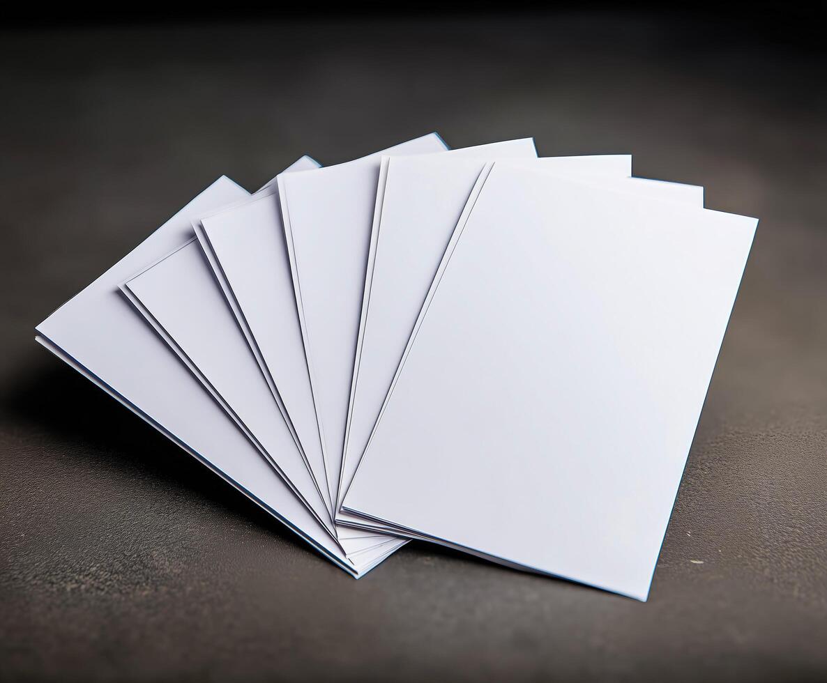 Blank white envelopes fanned on dark surface. photo
