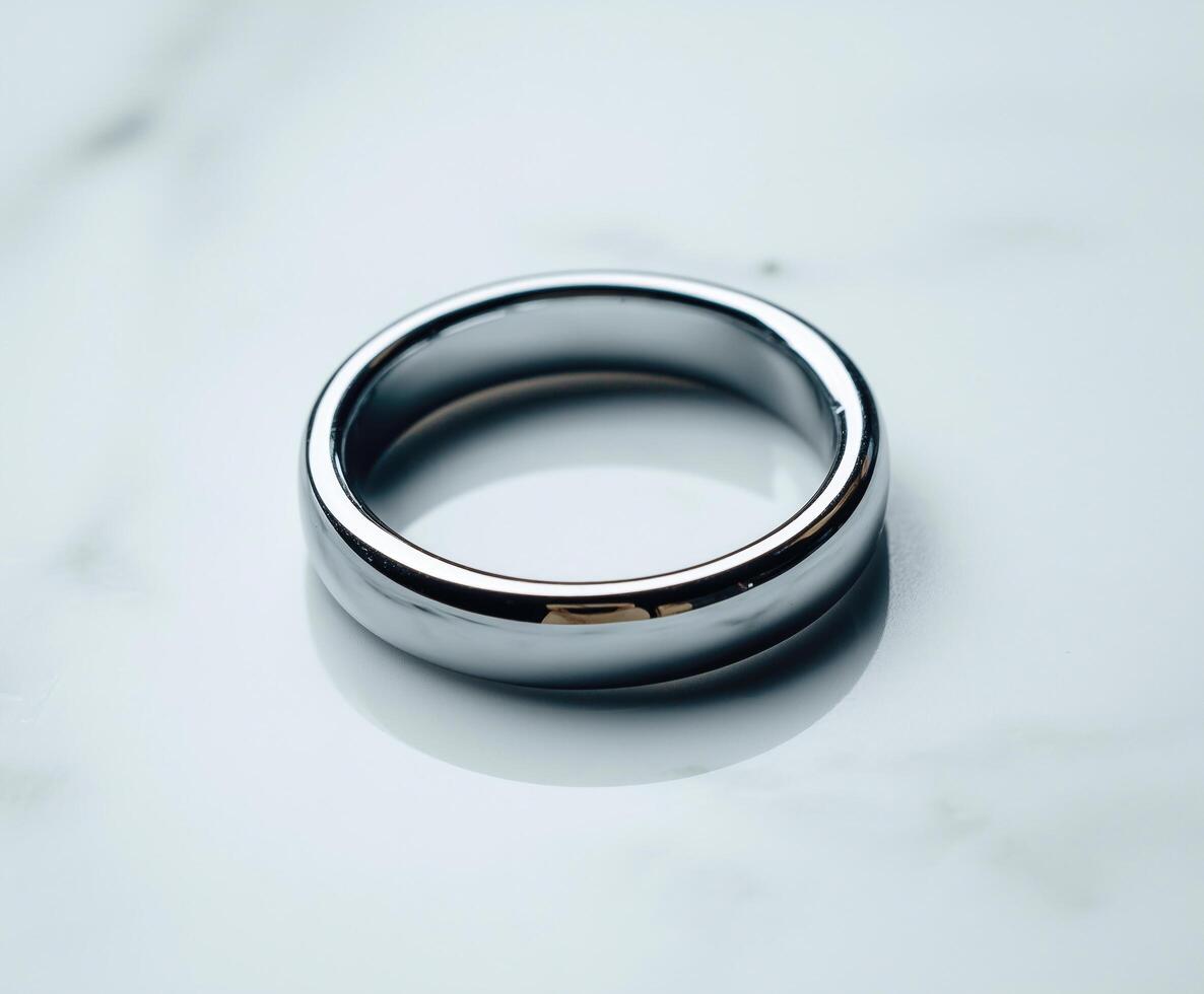Elegant silver ring resting on a smooth marble surface. photo