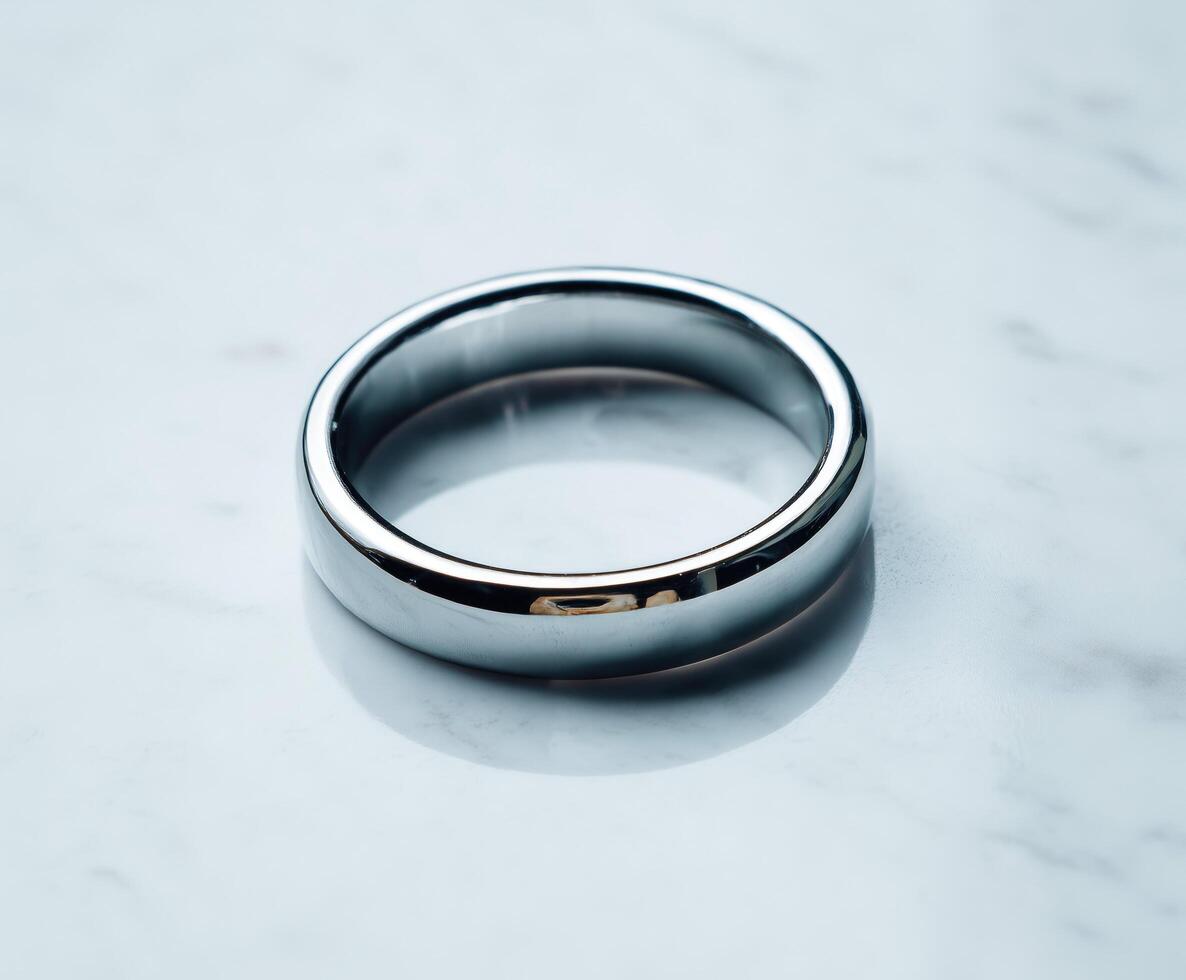 Minimalistic silver ring on smooth white marble background. photo