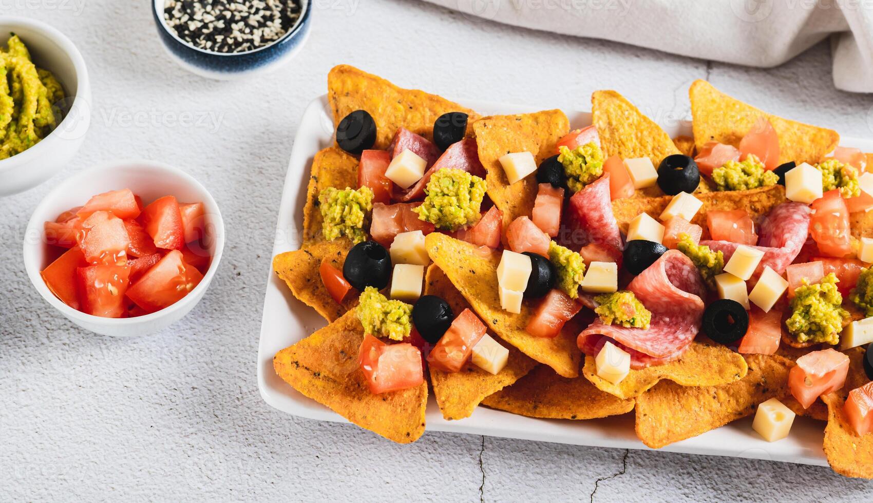 Appetizer plate with nachos, salami, cheese, tomato and black olives web banner photo