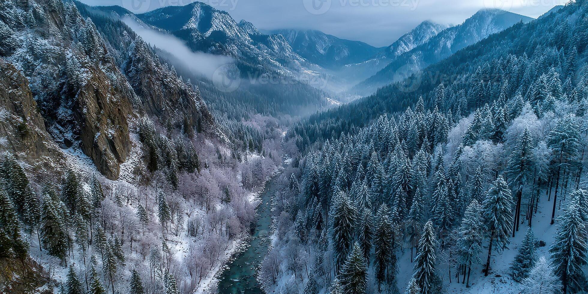 Expansive winter landscape showing a river winding through snow-covered mountains and dense forests in a serene environment photo