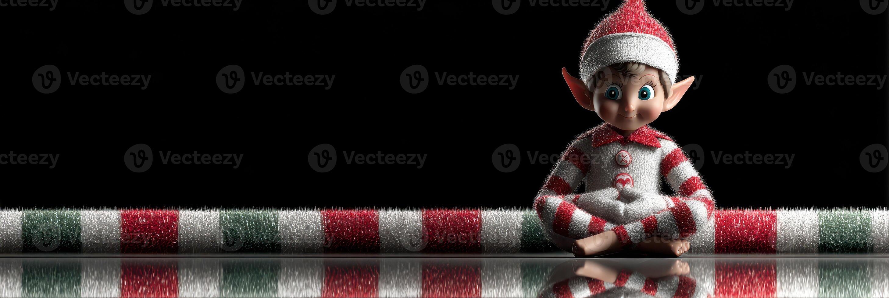 Cheerful elf doll sits on a festive striped surface with a dark background during the holiday season photo