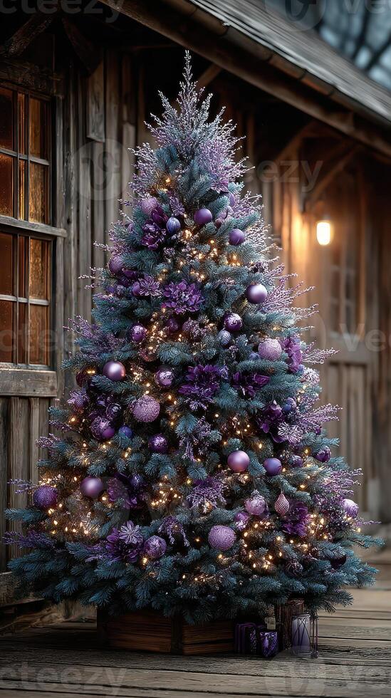 Beautifully decorated Christmas tree with purple ornaments and lights outside a rustic wooden building at dusk photo