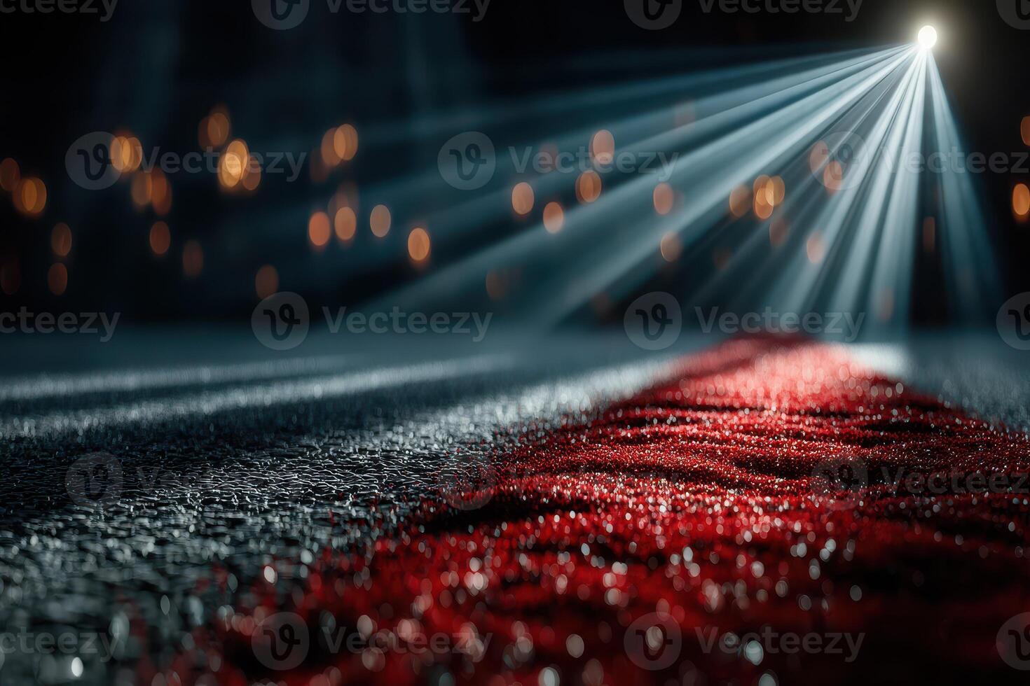 Dramatic red carpet leading to a spotlighted area in a darkened venue during an evening event photo