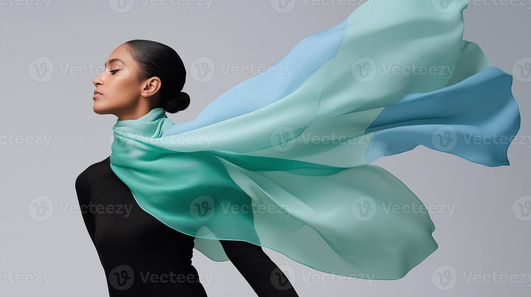 Elegant woman in black with a flowing ocean-colored scarf, evoking calm, movement, and marine inspiration in a minimalist fashion setting. Perfect for style and textile concepts. photo