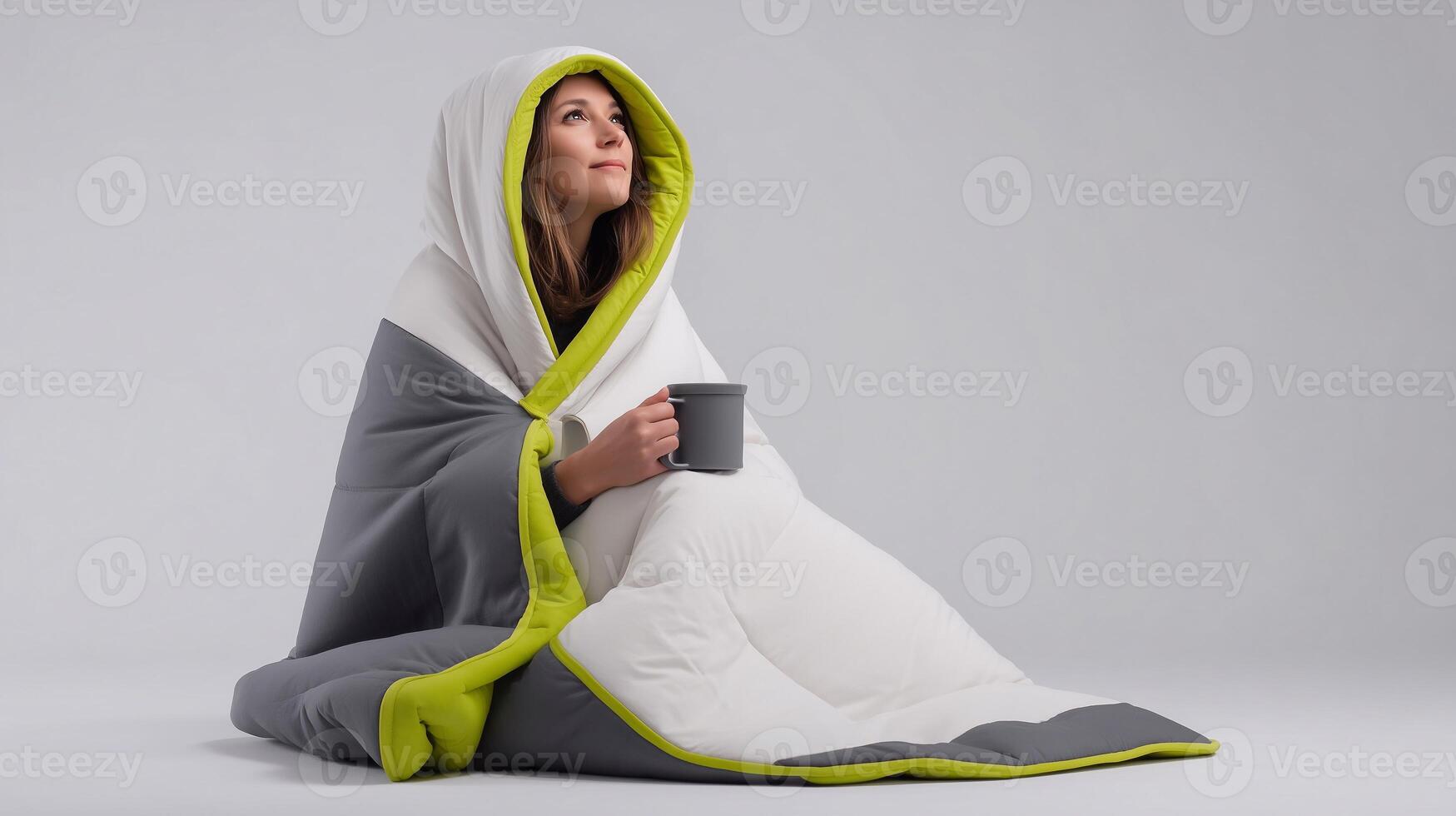 Young woman wrapped in a thick blanket with hood, holding a mug. Concept of home comfort, cold recovery, cozy warmth, winter wellness, and soft relaxation indoors. photo