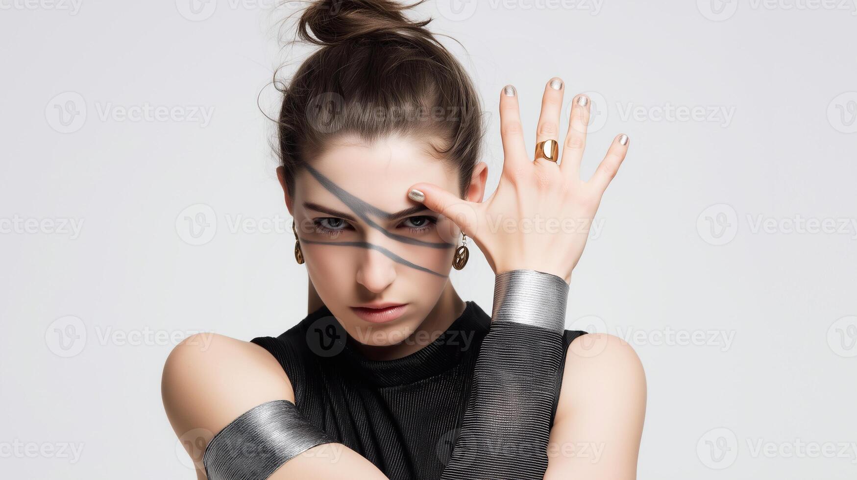 Fierce woman in black outfit with silver accents and bold face paint. Symbol of female power, resilience, and inner strength. Artistic fashion concept with minimalist background and dramatic pose. photo