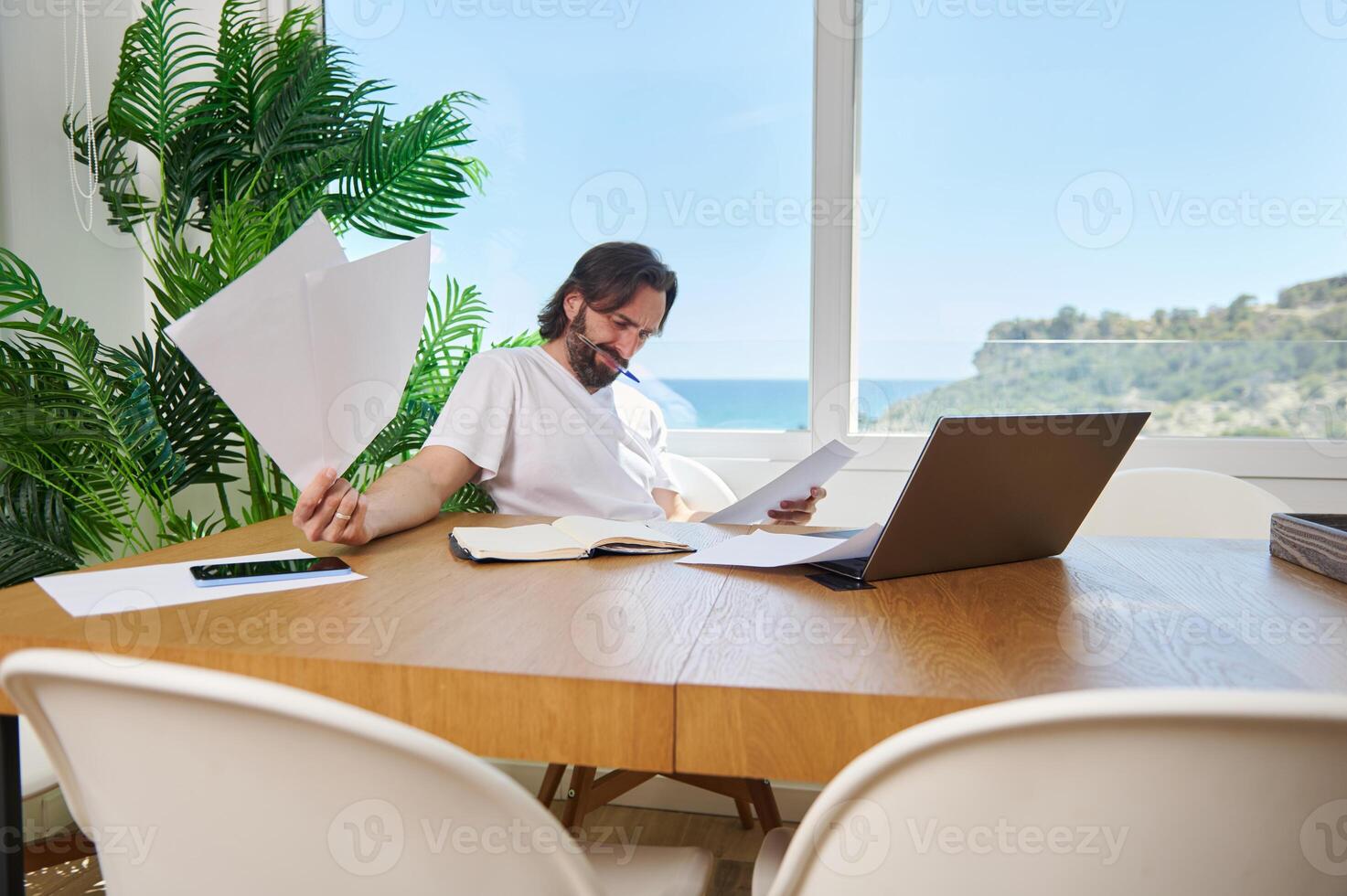 Freelancer Working Remotely at Minimalist Home Office With Ocean View photo