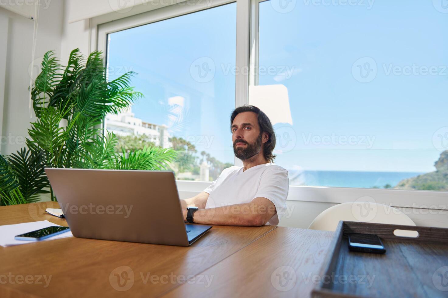 Freelance Professional Working Remotely from a Minimalist Home Office with Natural Decor and Scenic View photo
