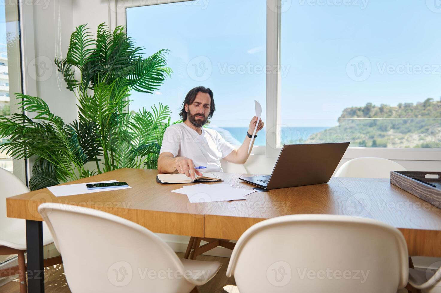 Relaxed Man Working Remotely in a Bright Home Office With Scenic Views photo