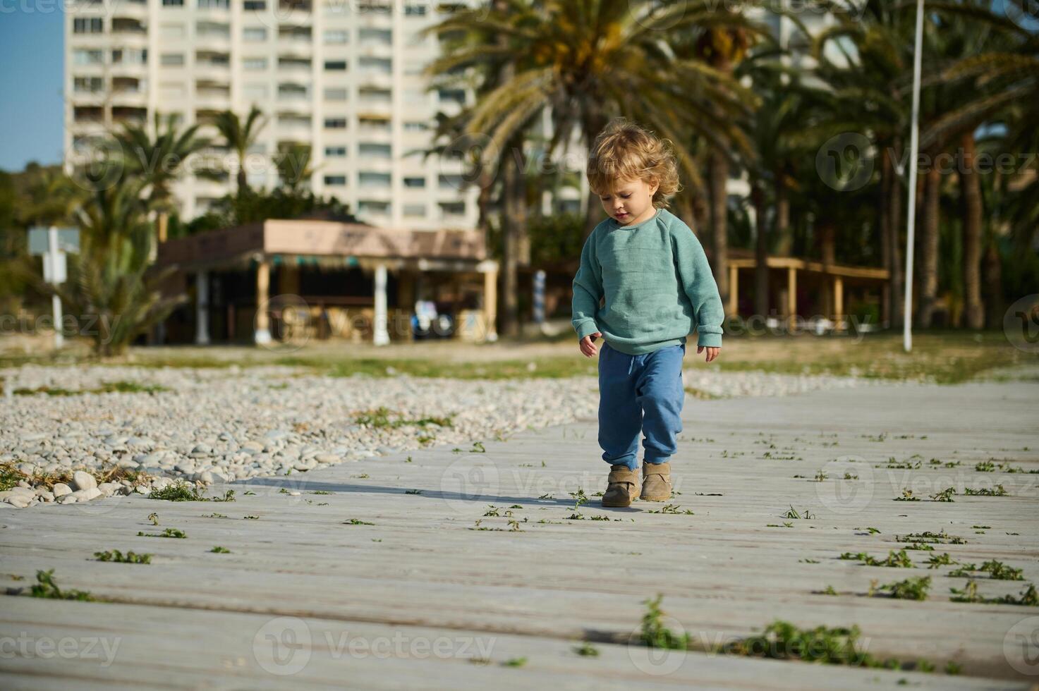 Young Child Walking Outdoors on a Sunny Day in an Urban Park Setting photo