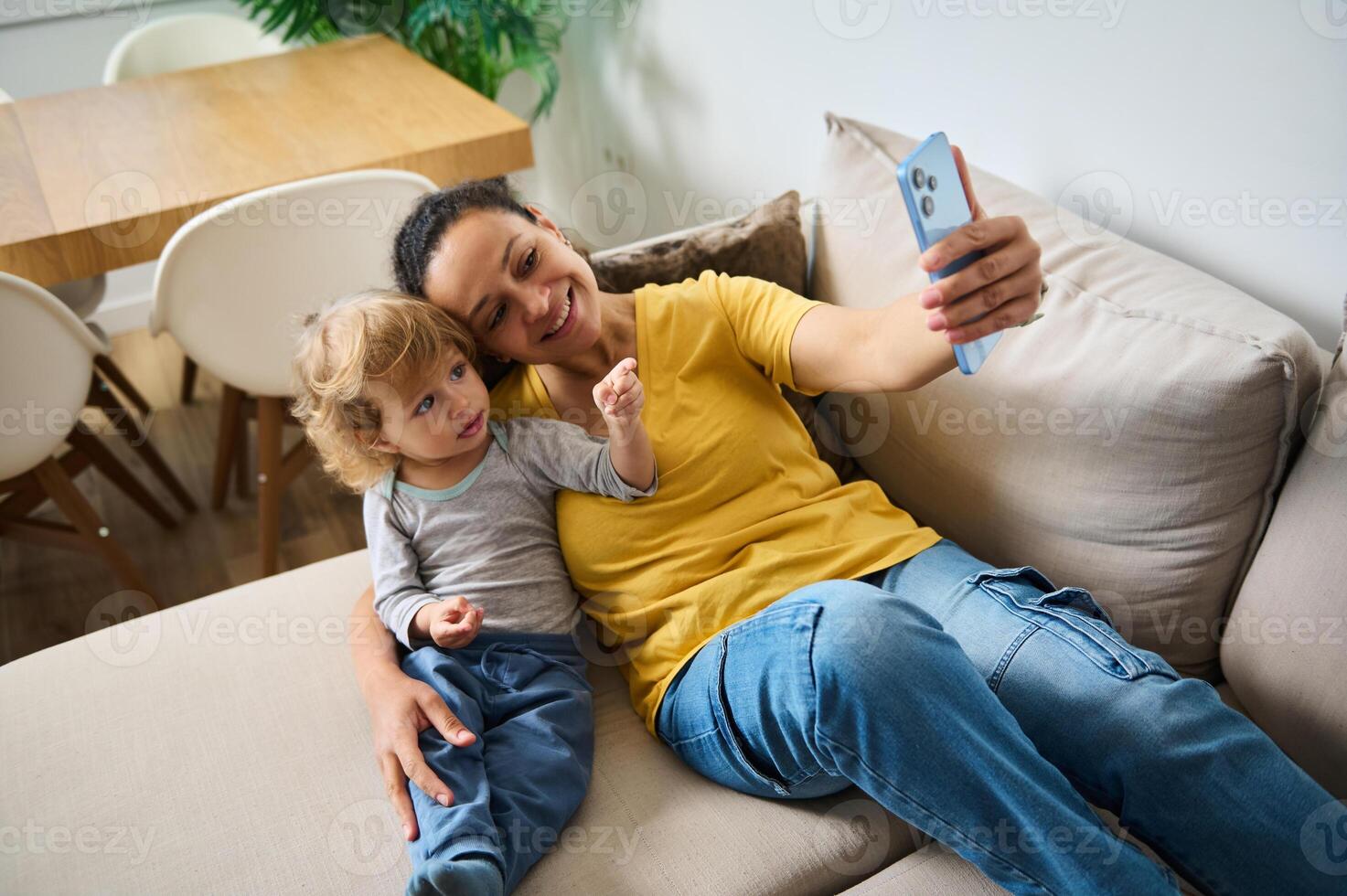 Mother and Child Taking a Selfie Together in a Cozy Living Room Environment photo