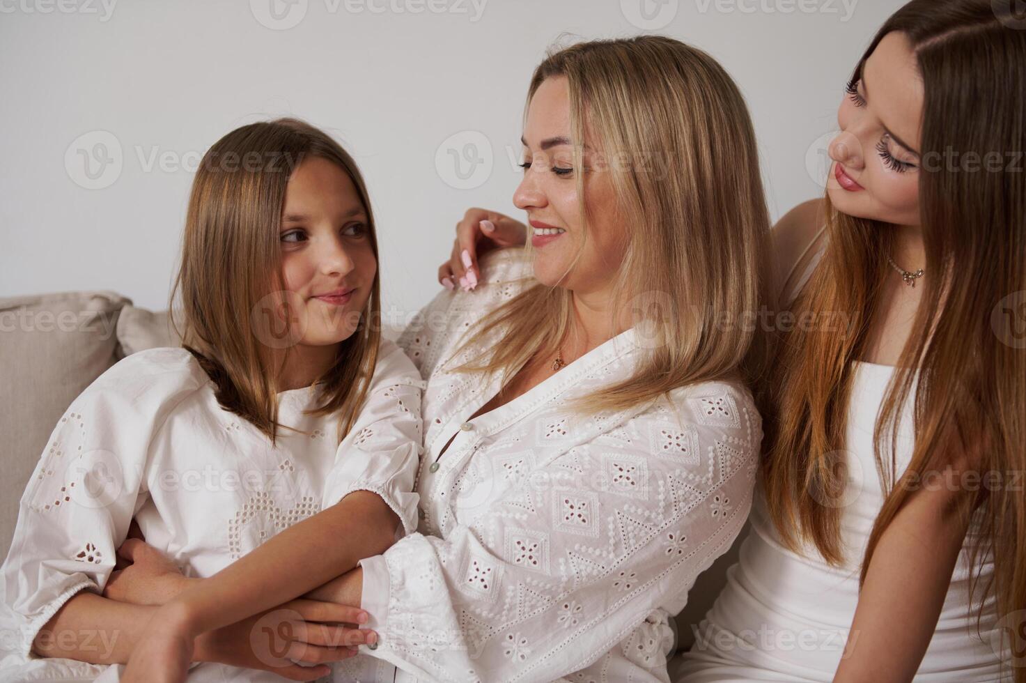 Happy Mother With Two Daughters On a Couch Expressing Family Bond photo