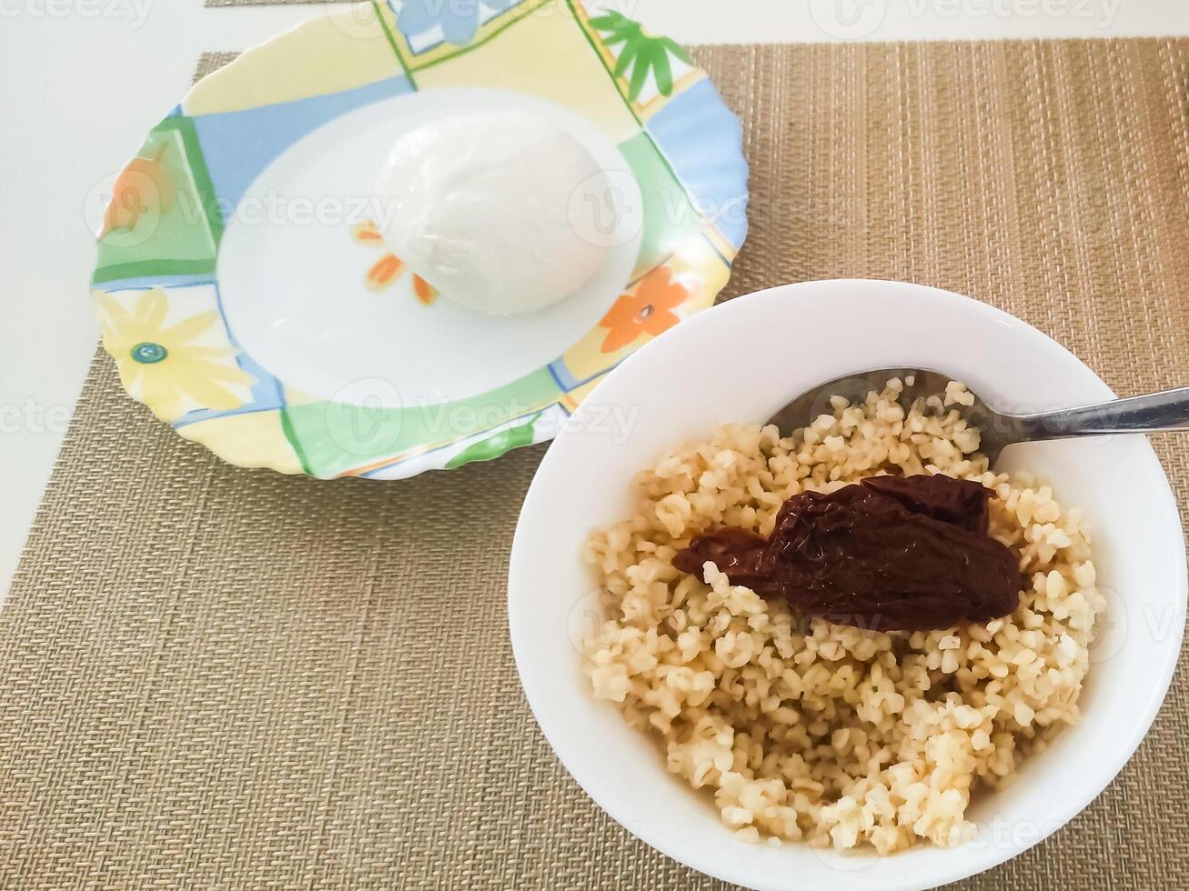 Delicious bowl of cooked grains topped with rich sauce served alongside creamy dessert and refreshing drink photo