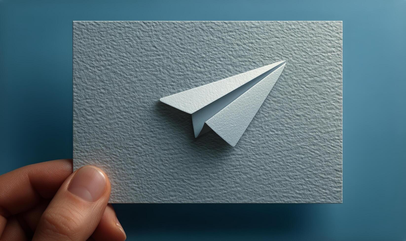 A person holding a paper airplane on a square card photo