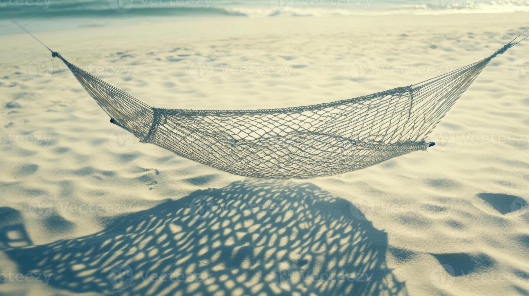 Beige Mesh Hammock on White Sandy Beach Under Warm Sunlight photo