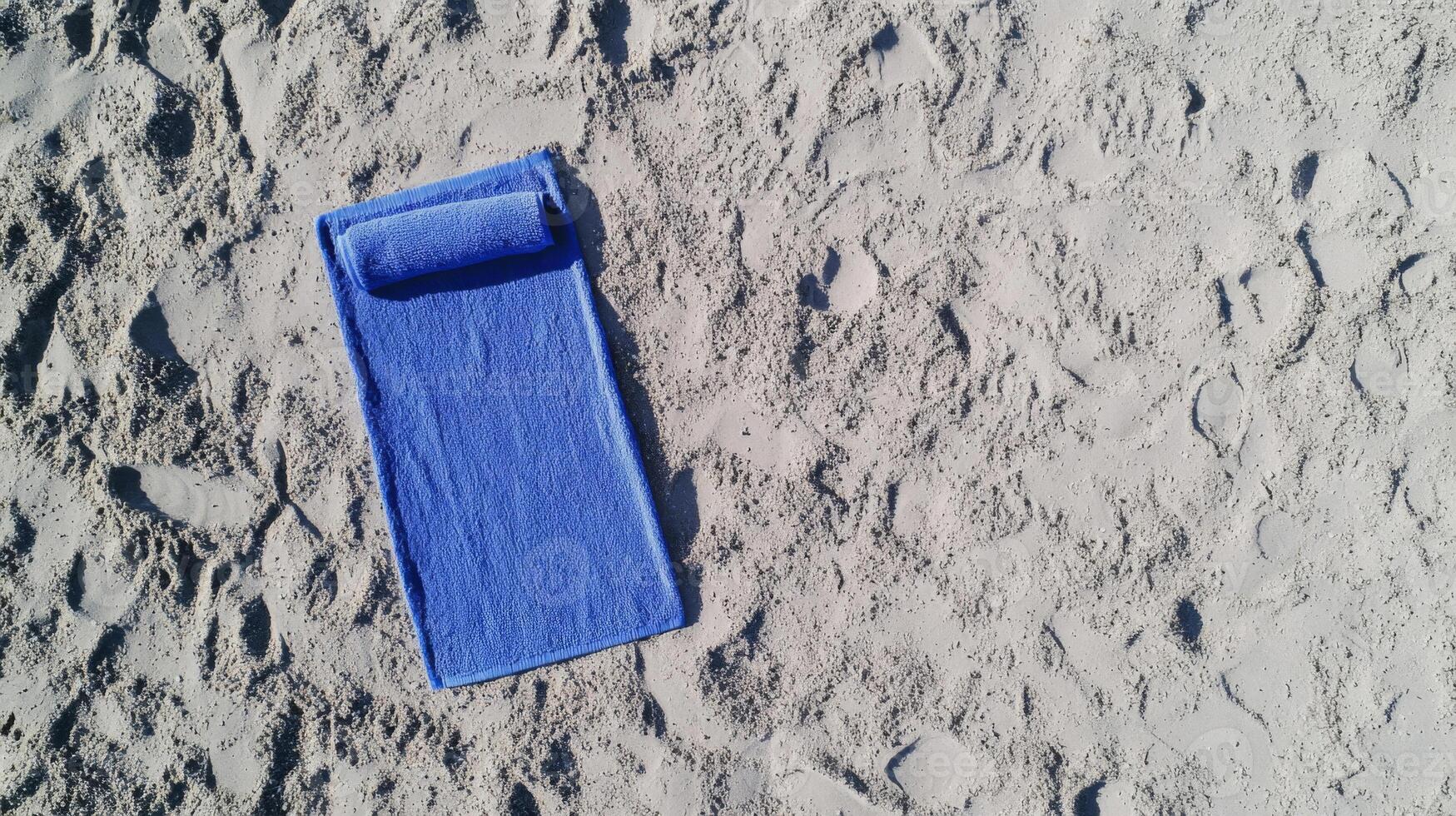 Blue Beach Towel on Sandy Beach photo