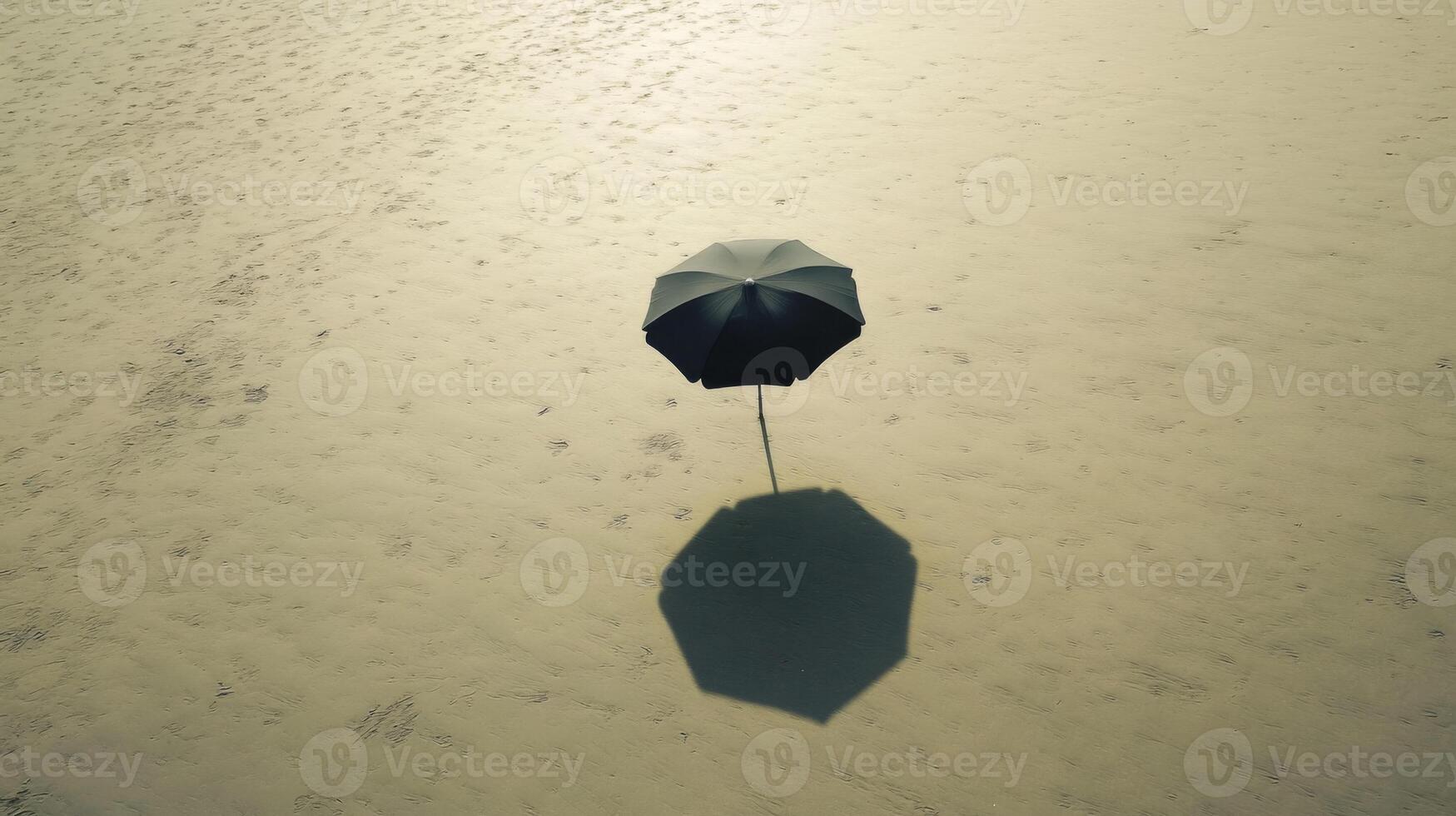 Black Umbrella Shadow on Sandy Beach photo