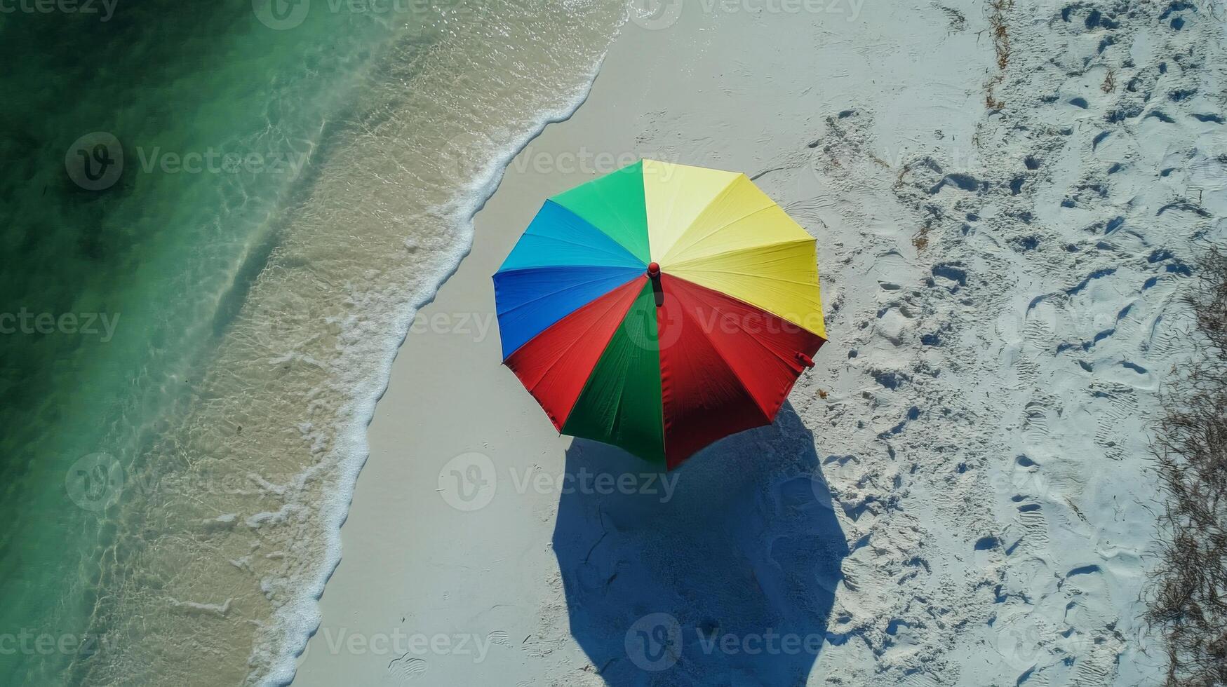 Woman Relaxing Under Colorful Umbrella on Sandy Beach photo