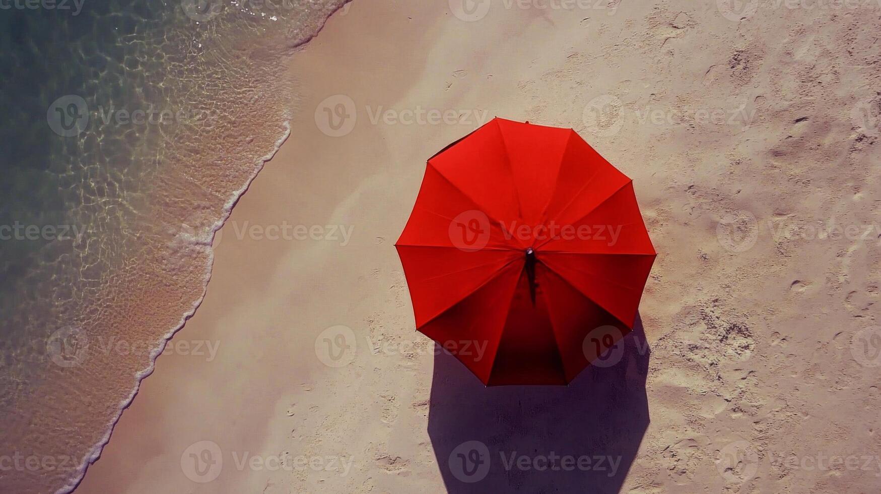 Red Umbrella on Sandy Beach with Person Walking Near Ocean photo