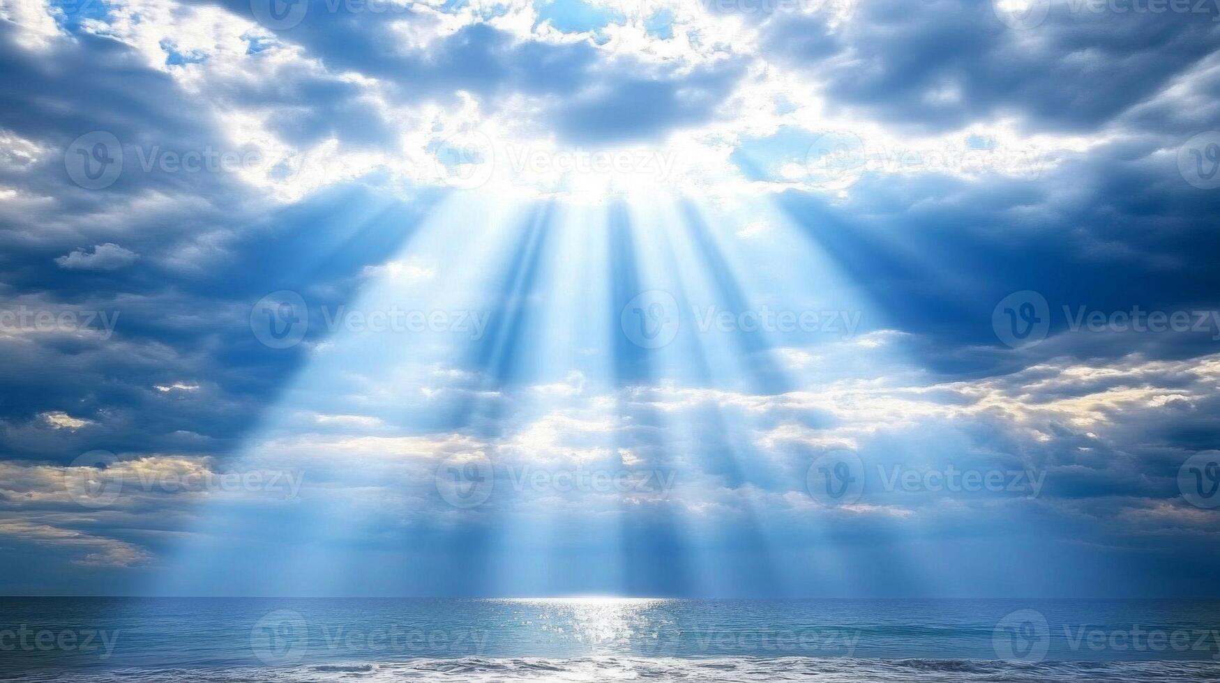 Bright Sunbeams Piercing Through Clouds Over a Serene Ocean photo