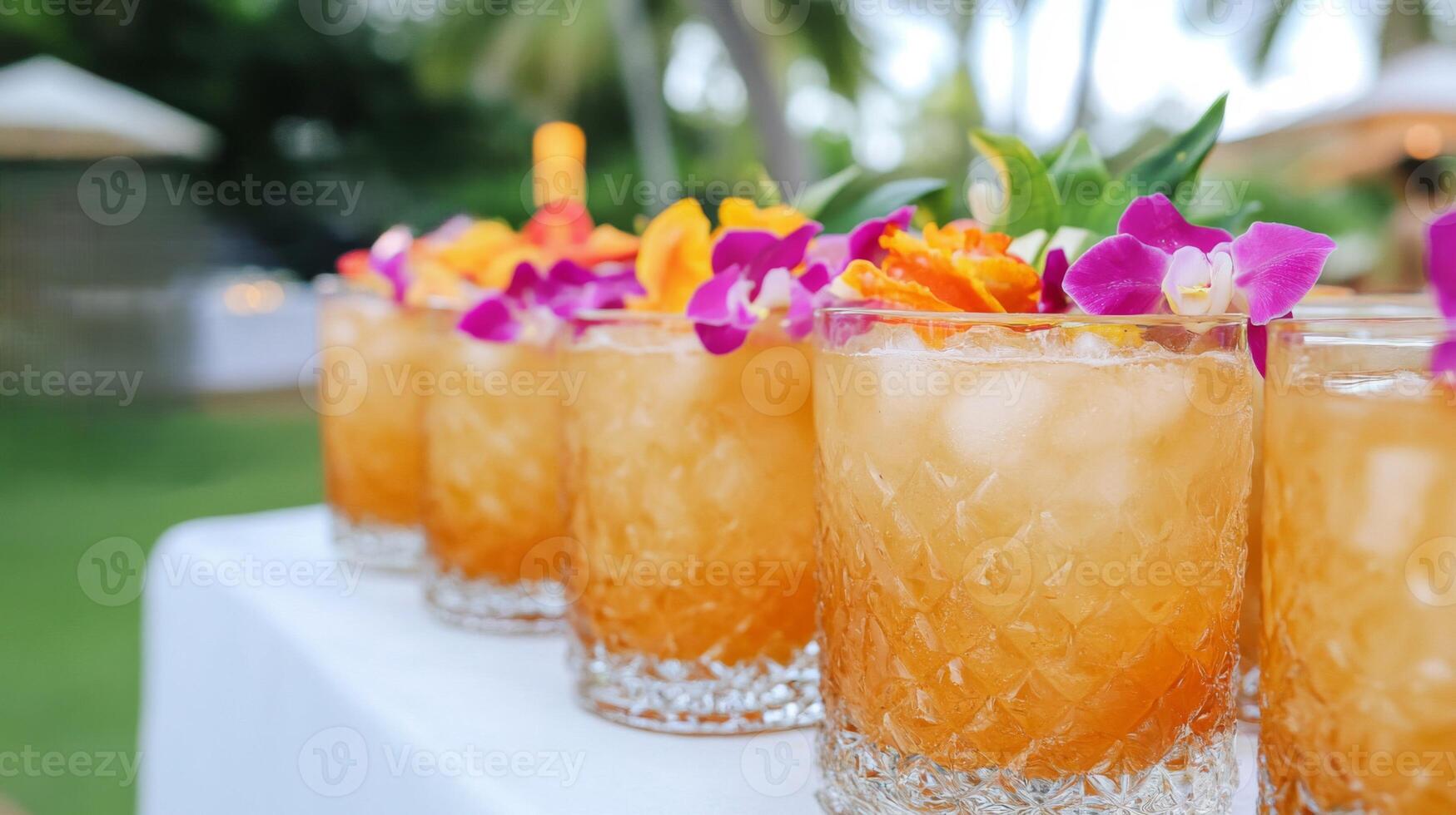 Row of Refreshing Amber Cocktails Garnished with Orchids and Citrus photo