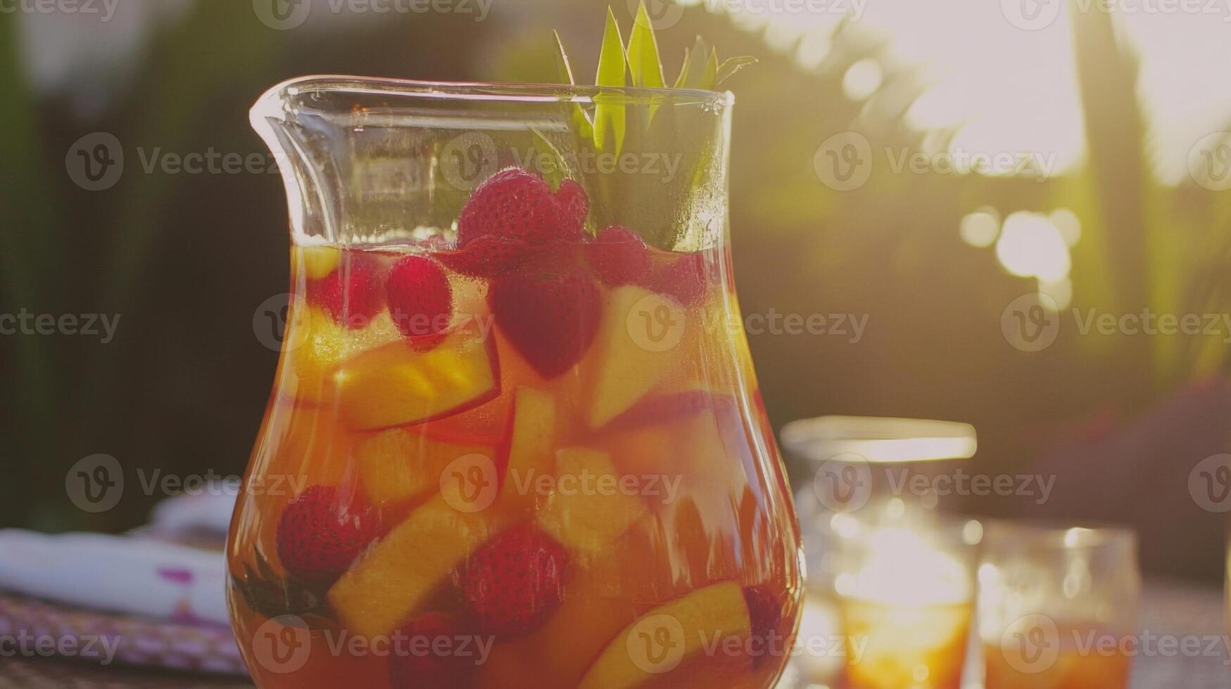 Sunlit Peach and Raspberry Fruit Punch in Glass Pitcher photo