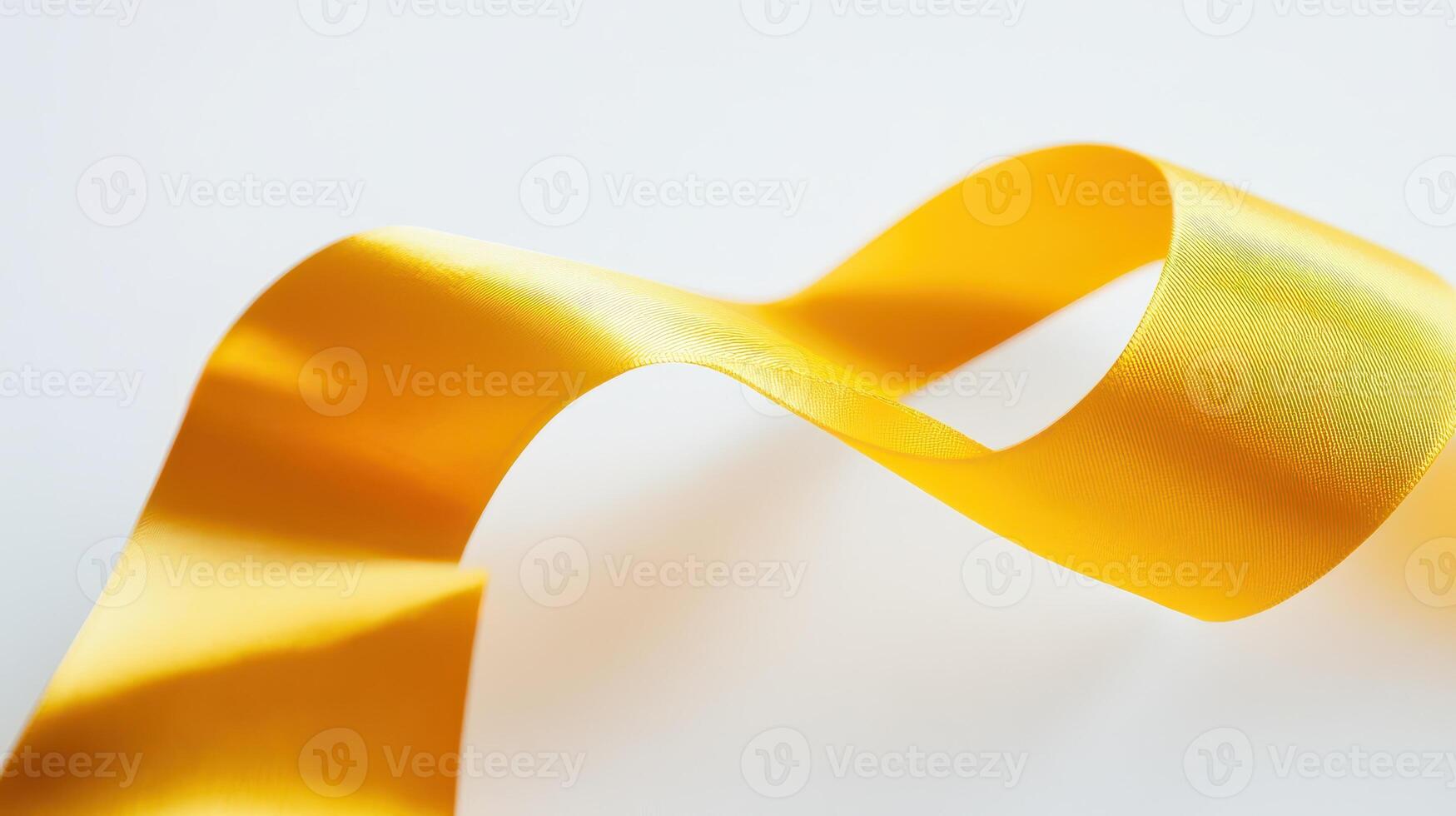 Yellow ribbon twisting on a light background photo