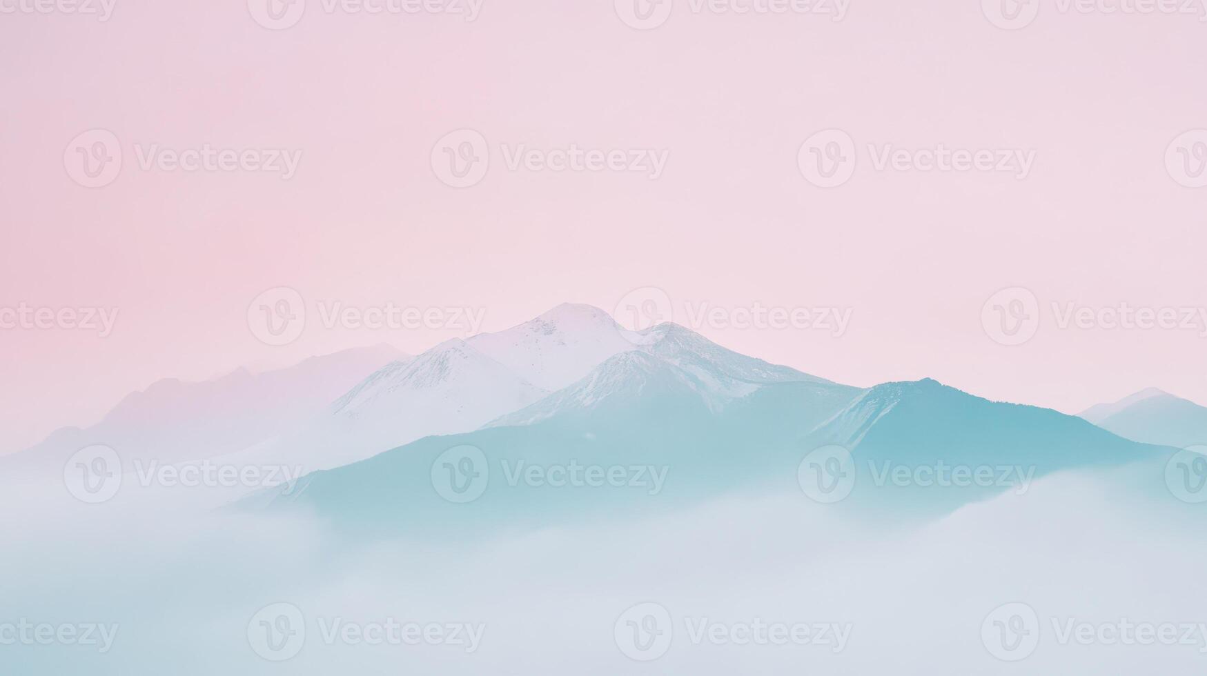 Mountains covered in mist at dawn with pink sky photo