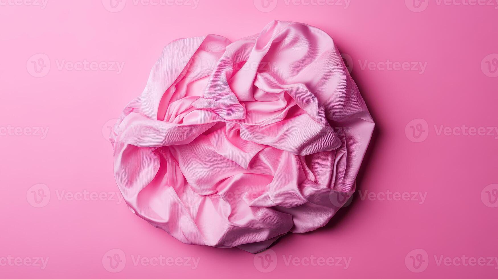 Soft pink fabric crumpled on a bright backdrop photo