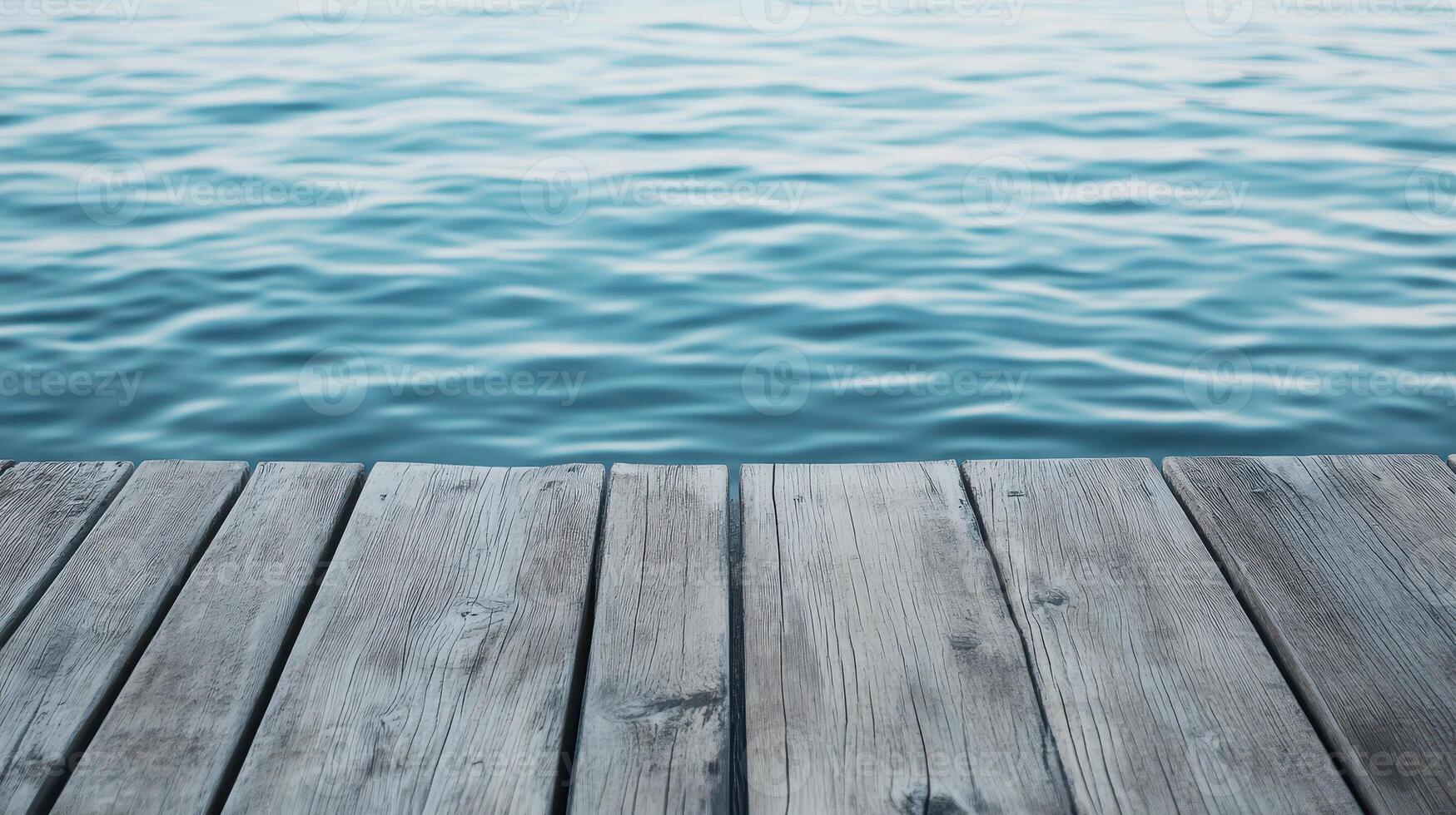 Wooden dock extends over tranquil blue waters photo